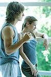 Young couple in exercise clothing standing by window