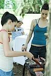 Family grilling meat on barbecue