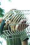 Boy taking piece of meat from grill, low angle view