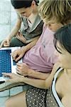 Young friends using laptop together, high angle view