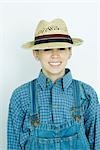 Teen girl wearing overalls and straw hat, portrait