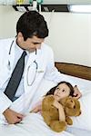 Doctor sitting next to sick child