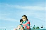 Children standing behind fence