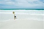 Enfant en cours d'exécution dans le surf à la plage