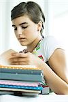 Teen Girl mit Stapel von Hausaufgaben, Porträt