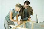 Paar macht Messungen auf Holz plank