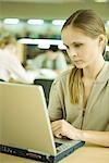 Young woman using laptop in library