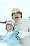 Grand-mère et petite-fille se faire frapper avec des boules de neige, souriant