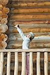 Girl standing on deck of wood cabin, stretching arms