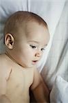 Baby in bed, looking down, close-up