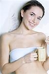 Junge Frau hält Teetasse, lächelnd in die Kamera, gekleidet in tubetop