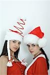 Two young female friends dressed in Christmas costumes, looking at camera, portrait