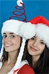 Two young female friends dressed in Christmas costumes, smiling at camera, portrait
