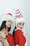 Two young female friends dressed in Christmas costumes, looking at camera, portrait