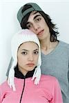 Young couple wearing hats, looking at camera, portrait