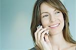 Woman using cell phone, smiling, portrait
