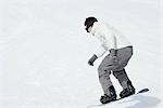 Jeune homme snowboard, pleine longueur