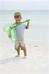 Kleiner Junge am Strand stehen für den Ball im Netz zu erreichen