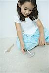 Girl sitting on the ground playing with top, close-up