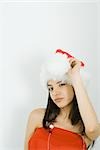 Teenage girl in Santa hat winking at camera, portrait