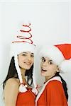 Deux jeunes amis portant des chapeaux Santa, souriant à la caméra