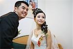 Bride and groom smiling together, looking away