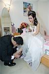 Bräutigam Putten Schuh am Fuß der Braut im Schlafzimmer