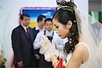 Chinese wedding, bride's hands clasped in prayer, side view