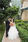 Bride and groom kissing, full length portrait