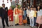 Newlyweds dressed in traditional Chinese clothing, standing with family, group portrait