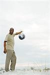 Man holding globe in plastic bag, looking at camera