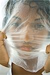 Woman with plastic bag over face, looking at camera