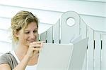 Woman on bench reading book, smiling, close-up