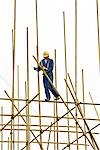 Man in hard hat assembling scaffolding