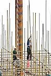 Construction workers on standing on scaffolding, low angle view