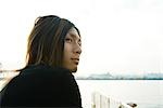 Young man outdoors, looking away, close-up