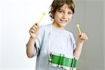 Little boy playing drum, smiling at camera