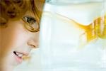 Little girl looking at goldfish in fishbowl, close-up