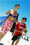 Mother and son walking at the beach, smiling at camera