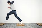 Young man running on footpath in gravel, side view