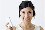 Young woman listening to MP3 player, smiling