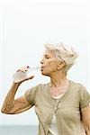 Senior woman drinking bottle of cold water