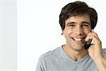 Man using cell phone, smiling at camera