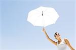 Woman holding up umbrella, low angle view