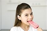 Little girl eating popsicle, smiling at camera