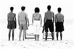 Family standing side by side at the beach, rear view