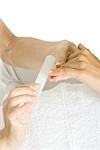 Woman receiving manicure, cropped view of hands