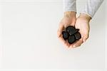 Hands holding black stones, overhead view