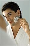 Man shaving, smiling at self in mirror