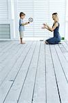 Mother and son playing catch on porch